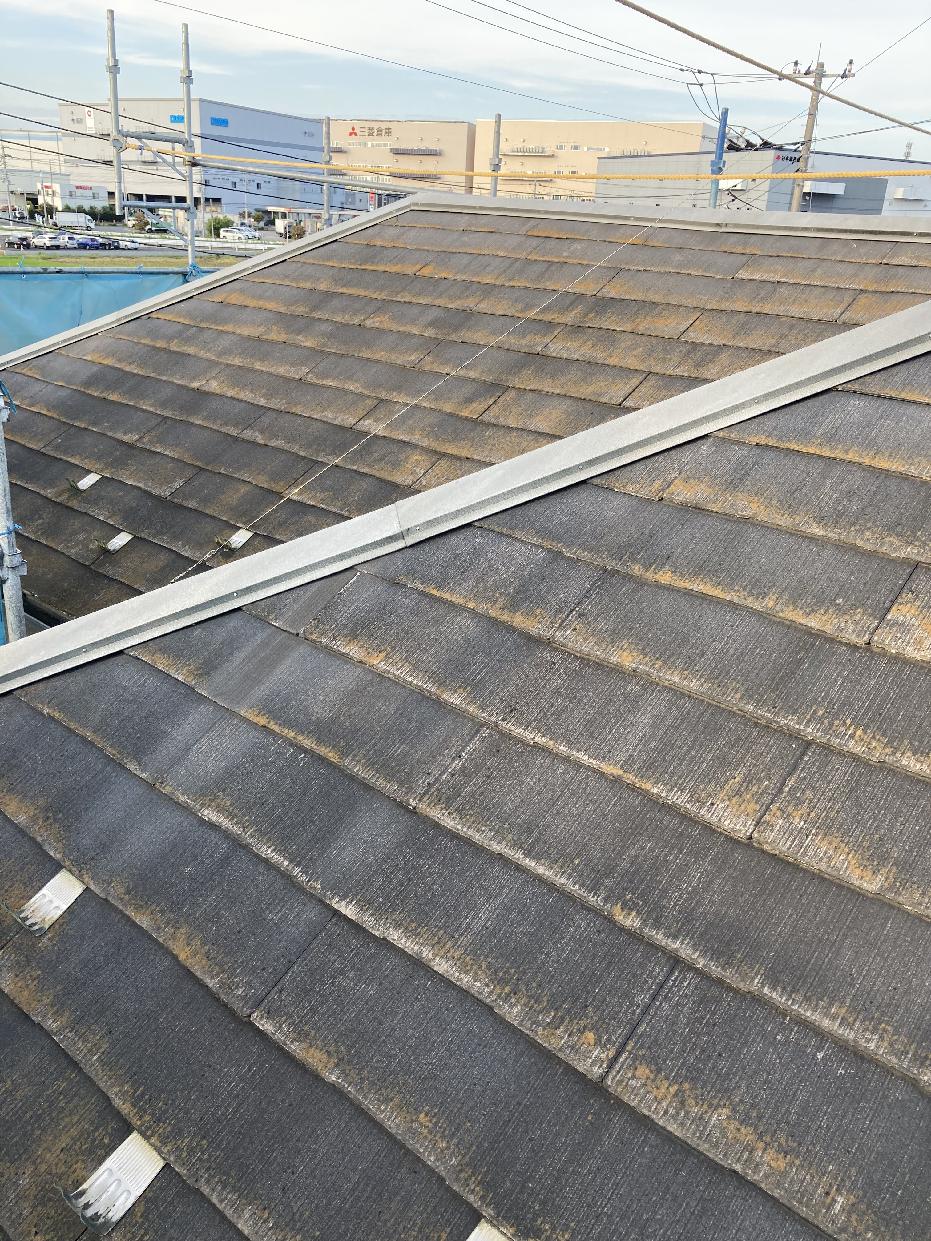経年劣化により色あせや苔の発生が見られる塗装前のスレート屋根
