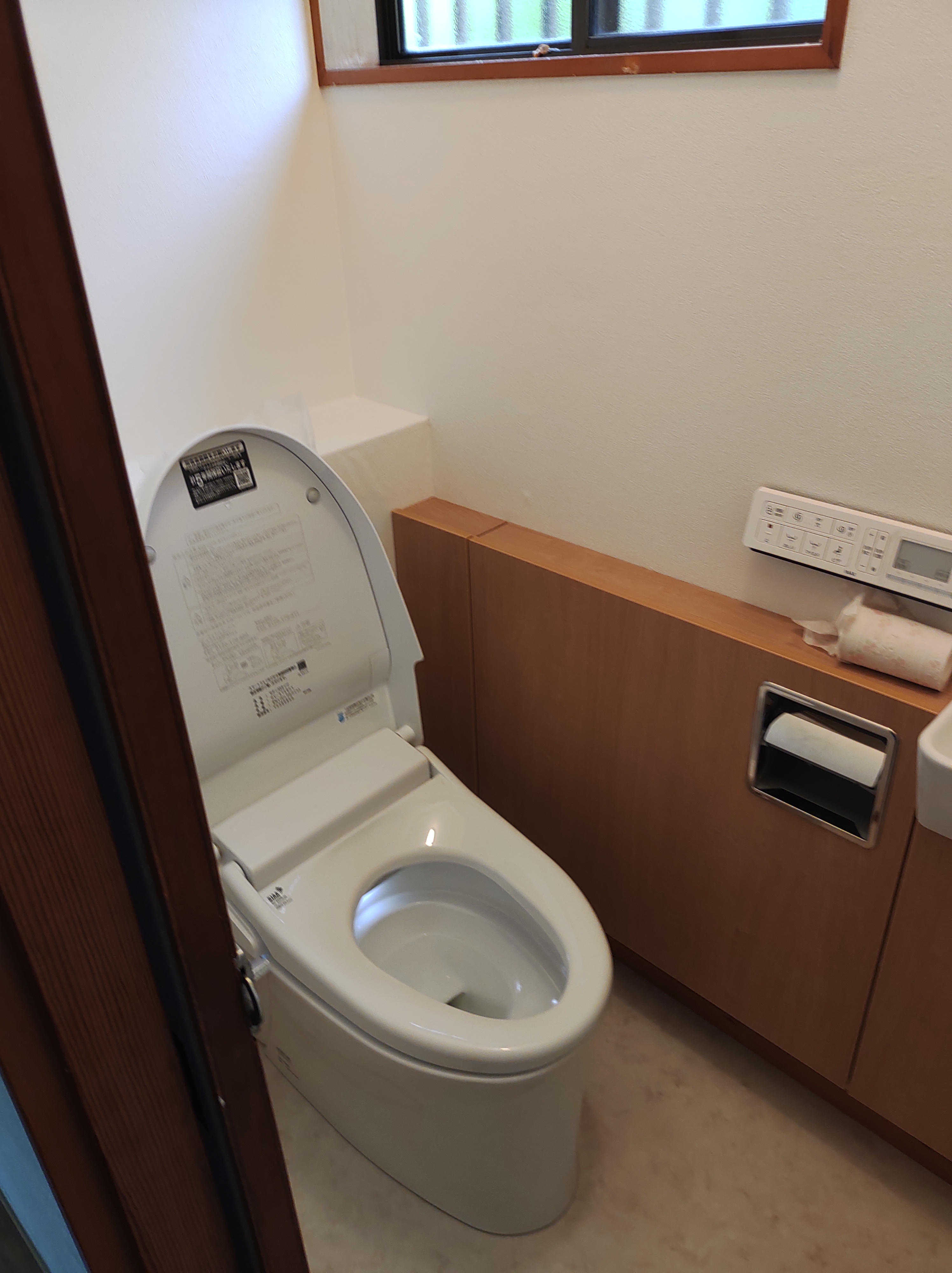 草加市でのトイレリフォーム施工例。LIXIL製の手洗い器付きタンクレストイレと、清潔感のあるクロス・CF貼り替え後。
