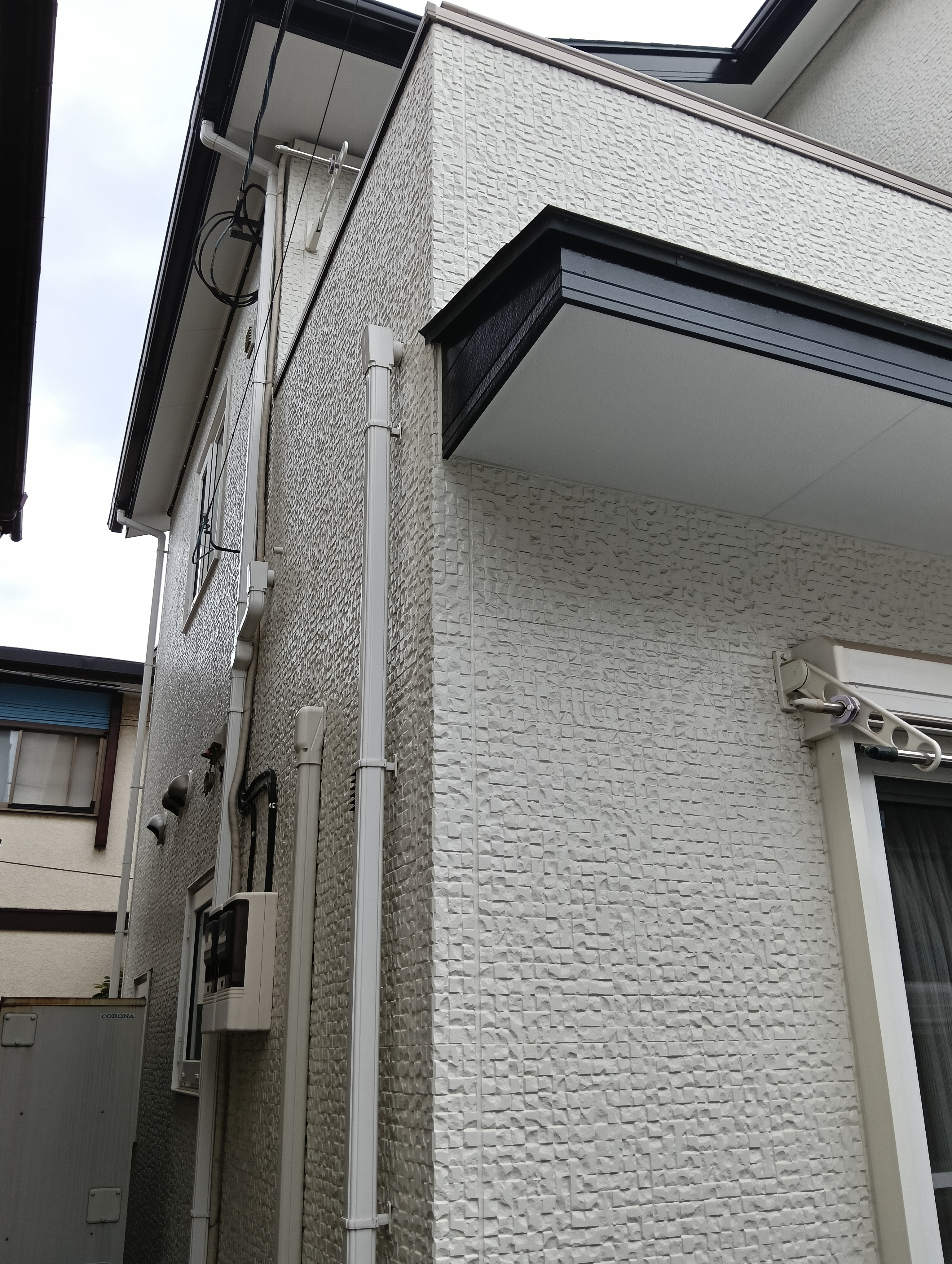 川口市での外壁塗装・屋根リフォーム施工事例。モダンな白外壁の雨だれ・黒ずみ汚れのお悩みを、セルフクリーニング機能を持つ低汚染塗料で解決!グレーのアクセント壁を引き締め、新築時の美しい輝きを再現しました。