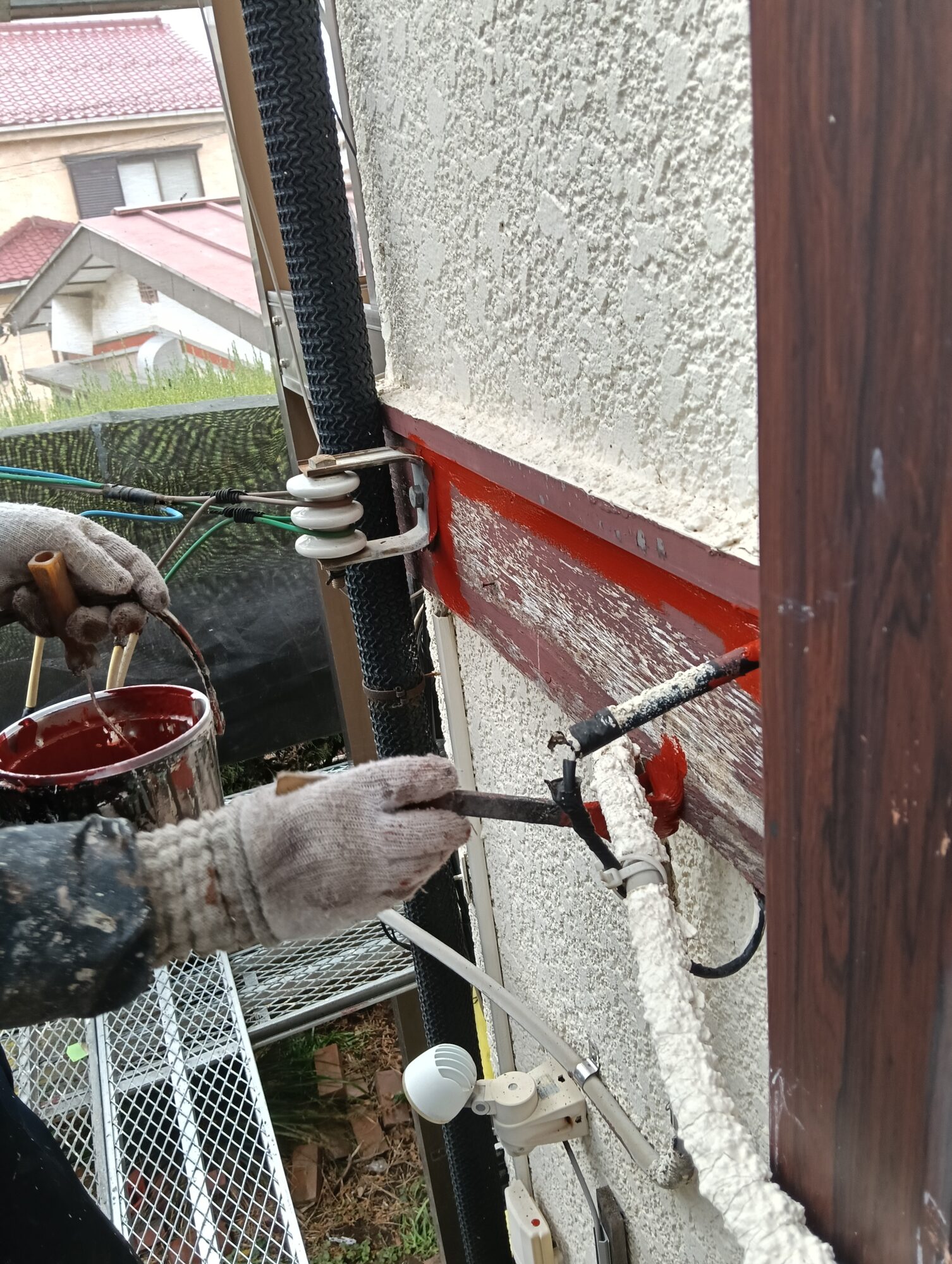 「草加市の住宅で行われている、雨樋や破風などの附帯部への下塗り塗装作業」