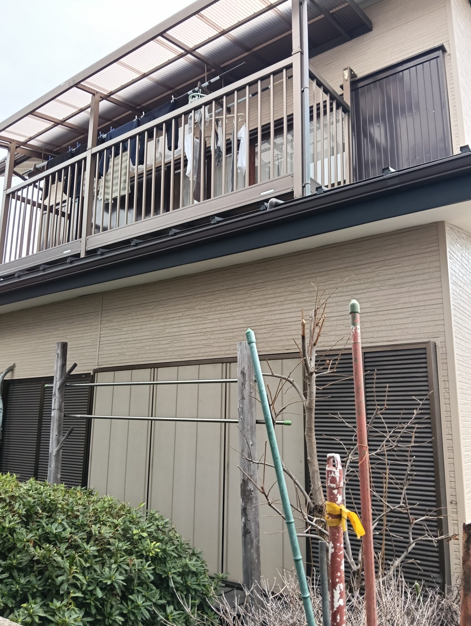 川口市での外壁リフォーム施工後。新しく張り替えたベージュ系の金属サイディングと、黒で美しく塗装・仕上げされた軒天や破風板、雨戸サッシまわりの外観クローズアップ。