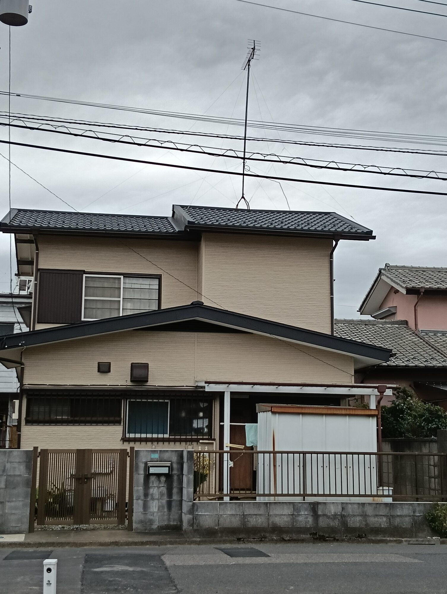 川口市での住宅リフォーム施工事例。外壁の金属サイディング張替え工事と、屋根の葺き替え工事が完了した和モダンな2階建ての住宅外観。